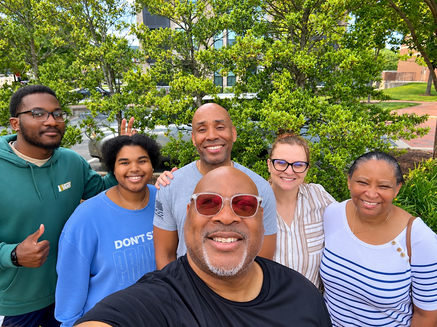 Six people smiling together outdoors
